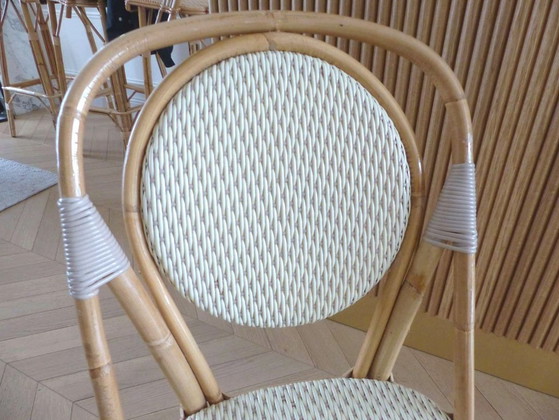 Image 1 of Een paar Parijse bistrostolen van Maison Louis Drucker in licht Manila-rotan.