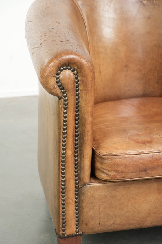 Image 1 of Vintage sheepskin club armchair with beautiful colors and finished with decorative nails.