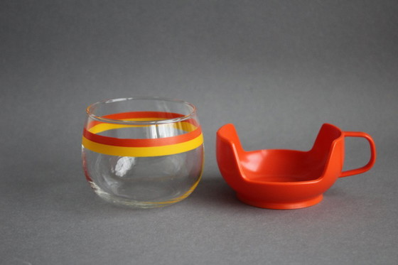 Image 1 of 12 vintage glazen theekopjes met geel-oranje strepen en oranje plastic houders.