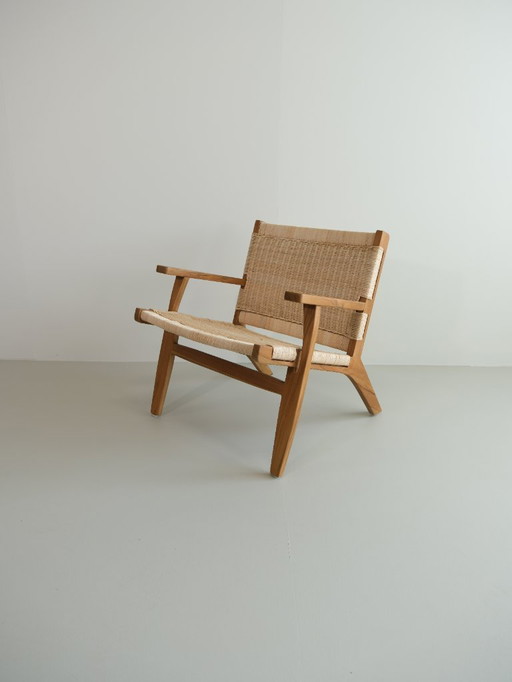 Poltrona lounge Valbona realizzata in teak massello e rattan intrecciato a mano.