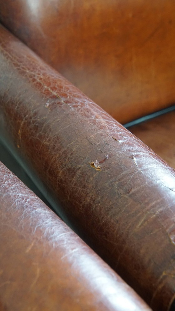 Image 1 of 4 x Vintage schapenleren eetkamerstoel met zwarte biezen op wieltjes