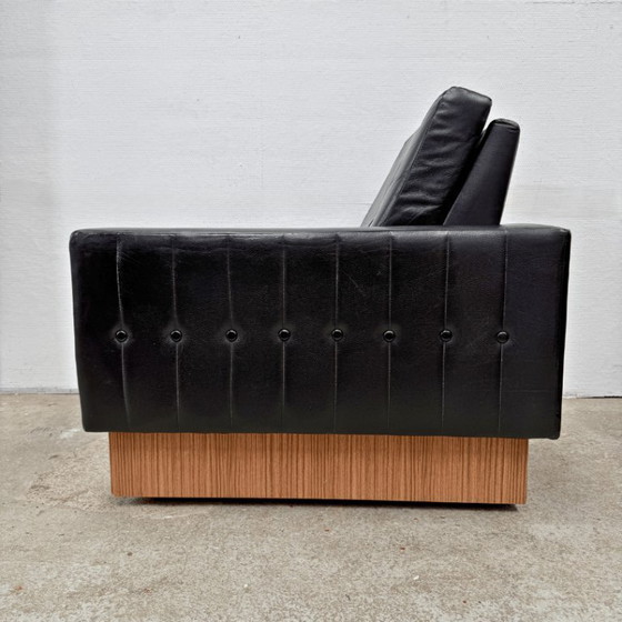 Image 1 of Sillón de diseño moderno de mediados de siglo en cuero negro con pedestal de madera.