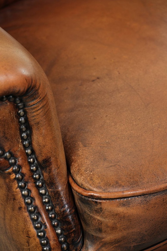 Image 1 of Comfortabele oorfauteuil gemaakt van schapenleer afgewerkt met siernagels en een karaktervolle uitstraling in Engelse stijl