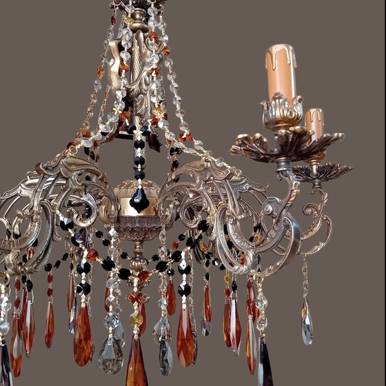 Image 1 of Una gran lámpara de araña de latón fundido con pátina.