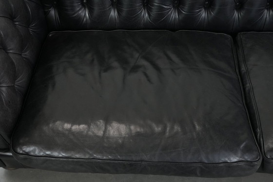 Image 1 of Set consisting of a black Chesterfield sofa, armchair and footstool made of cowhide