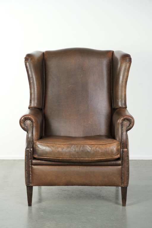 Grote karaktervolle schapenleren oorfauteuil met mooie warme kleuren en een prachtig patina in Engelse stijl