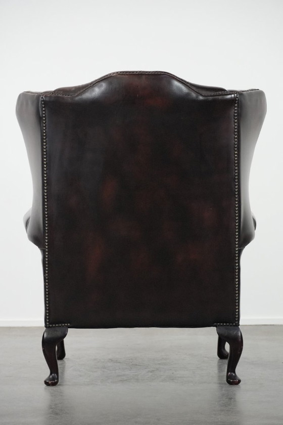 Image 1 of Poltrona Chesterfield con braccioli in pelle bovina marrone, in classico stile inglese.