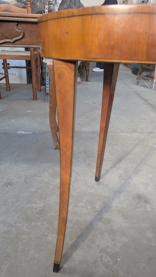 Tavolino di forma tonda, lastronato in noce, con gambe a sciabola