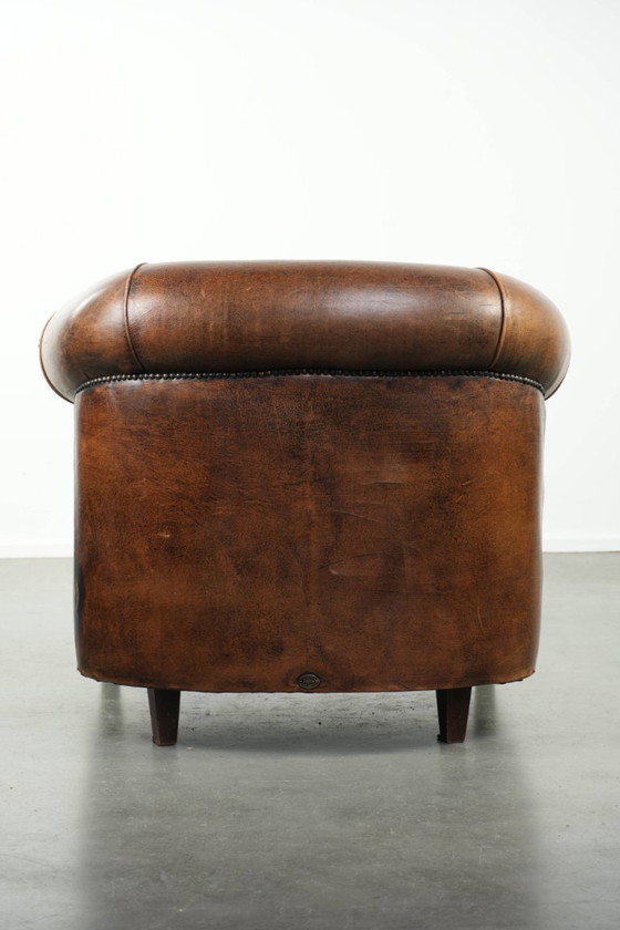 Image 1 of Karaktervolle en comfortabele clubfauteuil gemaakt van schapenleer met een vast zitkussen en uitmuntende kleuren