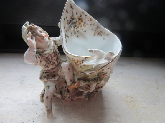 Image 1 of Jarrón antiguo con forma de concha, decorado con un elfo/bufón/niño y un pájaro - Volkstedt