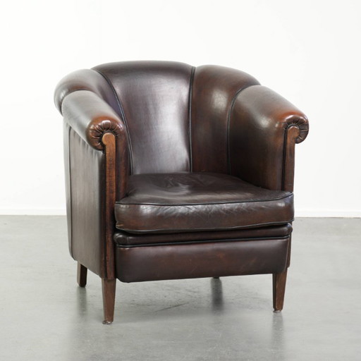 Donkere schapenleren clubfauteuil met een unieke vormgeving en een begeerlijk patina in Engelse stijl