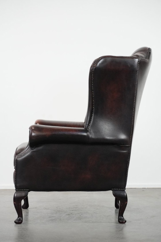 Image 1 of Poltrona Chesterfield con braccioli in pelle bovina marrone, in classico stile inglese.