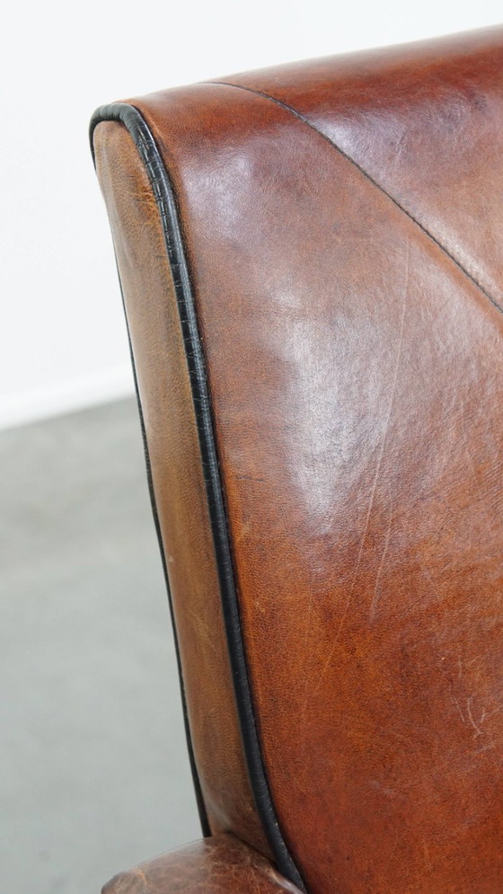 Image 1 of 6 x Vintage sheepskin dining chair with black piping on wheels