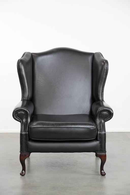 Sillón Chesterfield de piel de vaca negra lisa con respaldo alto y estilo inglés, con ribetes a juego.