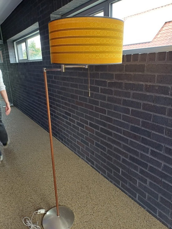 Image 1 of Dies ist eine Stehlampe aus Walnussholz im Mid-Century-Modern-Stil mit einem ockergelben Stoffschirm.