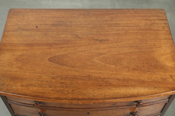 Image 1 of Antieke 19e eeuwse Engelse Bow front ladekast in een uniek subtiel formaat met mooie warme kleuren