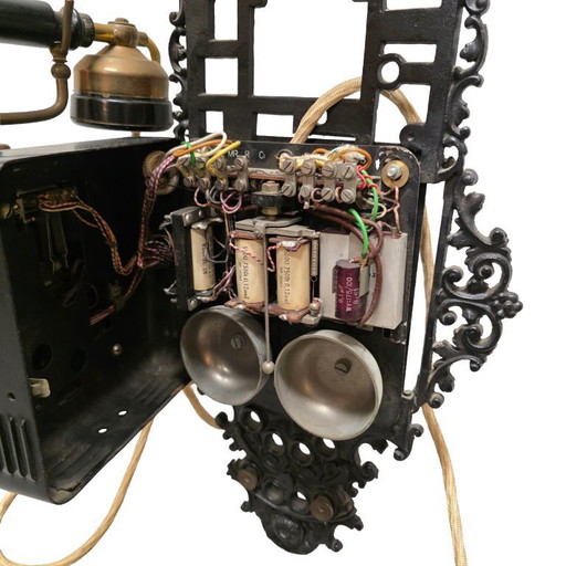 Ancien téléphone mural à cadran rotatif en fonte, début des années 1900
