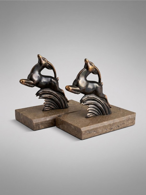 Image 1 of Serre-livres Art Déco en régule patiné – paire animalière stylisée – socles en marbre taupe – années 1930