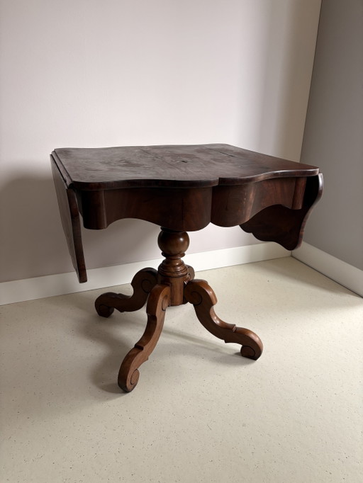 Tavolo vintage inglese in noce con gambe a ribalta, piano a crosta di torta e gamba centrale a cabriole.