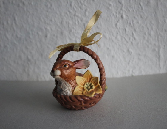 Image 1 of Un conejito adorable en una cesta con una flor amarilla. Goebel Edición Limitada Sorpresa de Pascua 2001