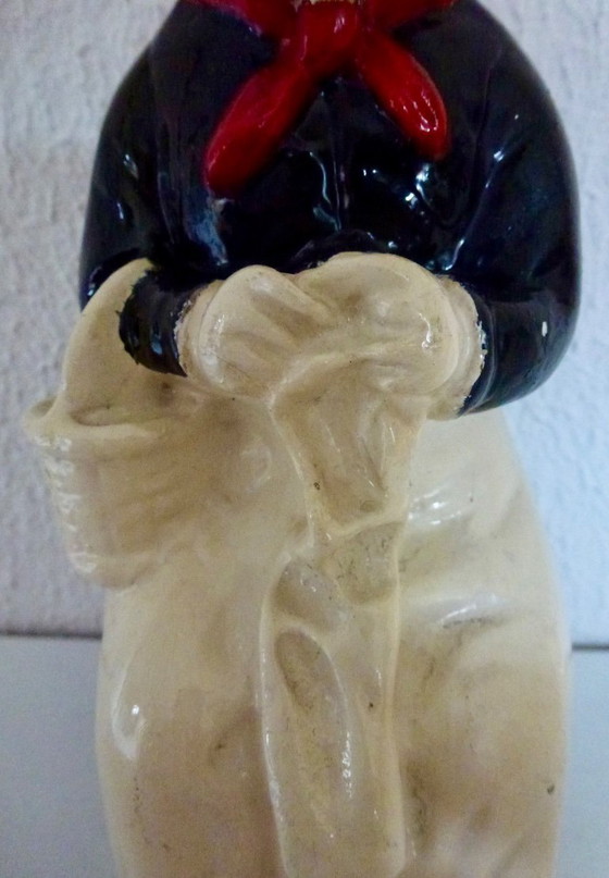 Image 1 of A set of decorative bookends depicting an elderly couple sitting on chairs.