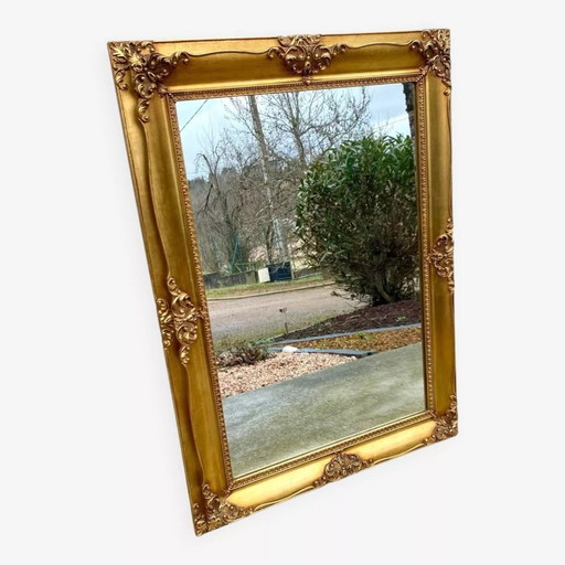 Beveled mirror in gilded wood