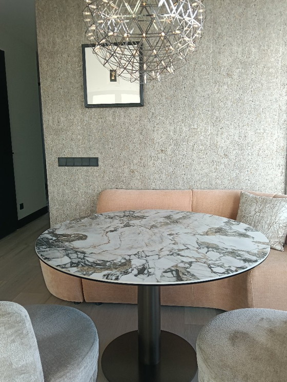 Image 1 of Mesa de comedor con tablero de cerámica mate y patas de bronce.