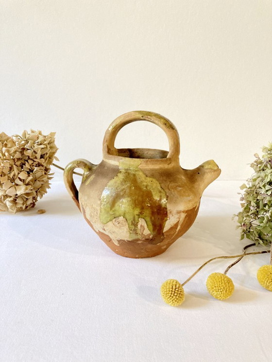 Image 1 of Klein Provençaals kannetje in de vorm van een geit, gemaakt van crèmewit en lichtgroen geglazuurd aardewerk.