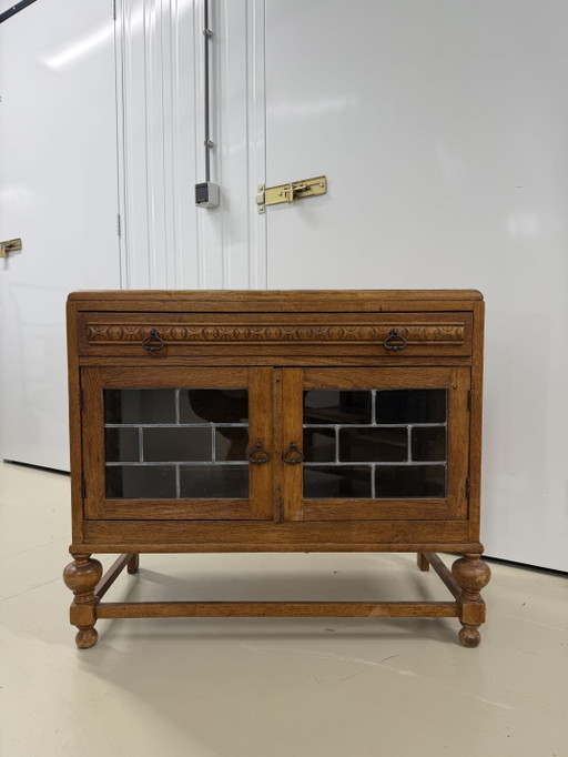 houten kast met twee deuren van loodglas en lade