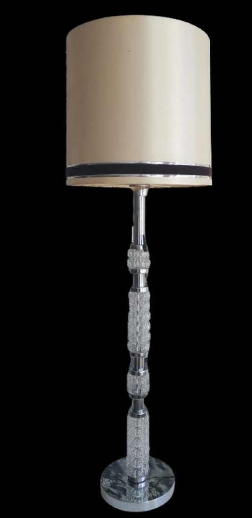 Staande lamp uit de jaren 70, de voet is gemaakt van verchroomd metaal en glas.