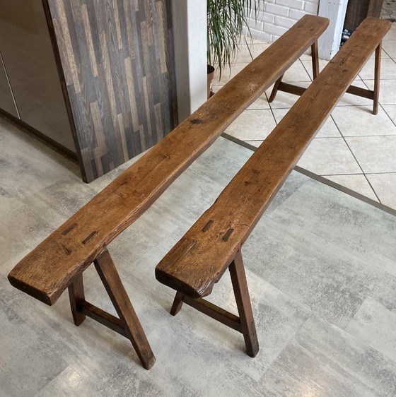 Image 1 of Twee massief eikenhouten boerenbanken van 214 cm voor een rustieke boerentafel uit de jaren 50.