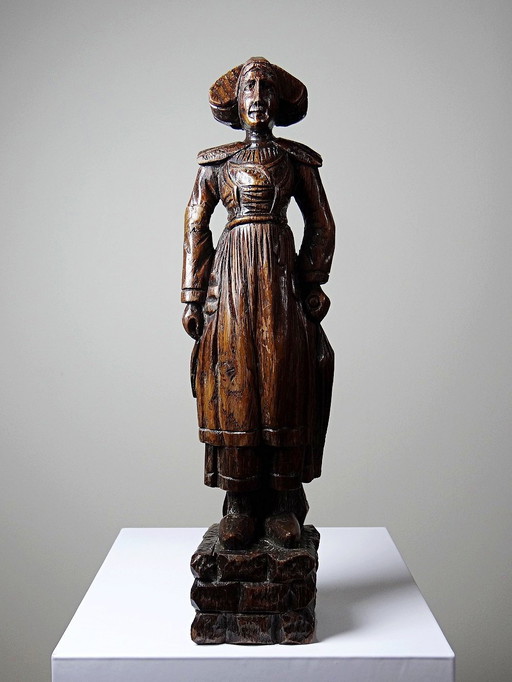 Antique wooden statue of a Breton woman in traditional dress