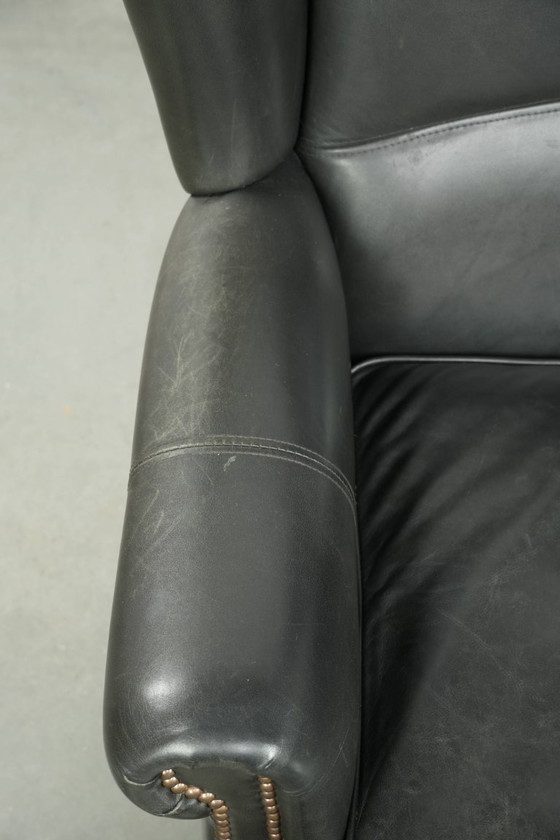 Image 1 of Zwarte rundleren oorfauteuil in een klassiek Engelse stijl