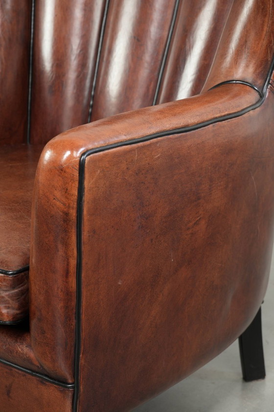 Fauteuil unique en peau de mouton aux couleurs chaudes et profondes, orné d'un passepoil noir. – Leather (photo 12 of 14)