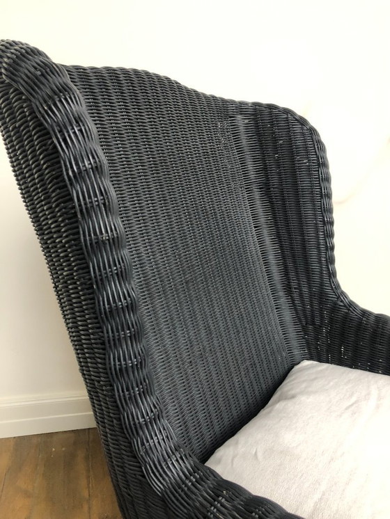 Image 1 of Fauteuil relaxant en osier noir et piètement en acier inoxydable.