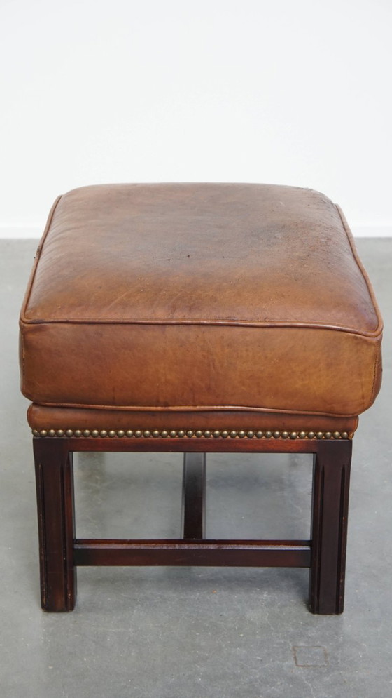 Image 1 of Hocker in pelle di pecora con struttura in legno e finitura con rivetti decorativi