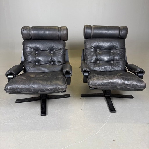 Pair of black leather, metal and wood Mid-Century Modern spinning armchairs in good condition with small signs of aging, 2 items