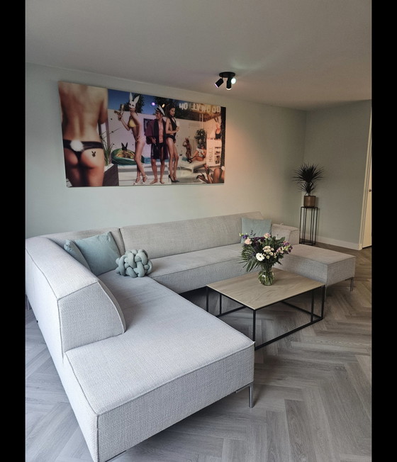 Image 1 of Modèle sur bloc de stock, comprenant un coin salon et un pouf séparé.