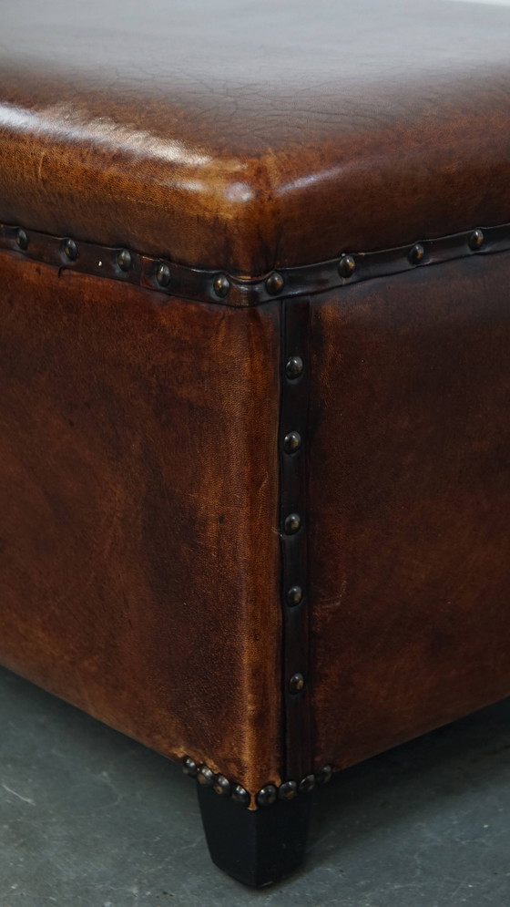 Image 1 of Cognac-kleurige schapenleren hocker met siernagels