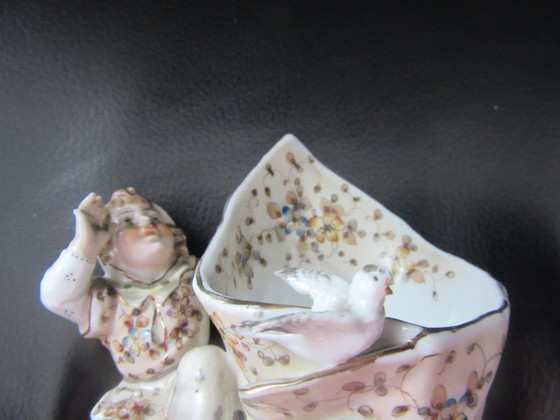 Image 1 of Jarrón antiguo con forma de concha, decorado con un elfo/bufón/niño y un pájaro - Volkstedt