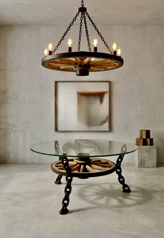 Image 1 of Tafel in de vorm van een wagenwiel met een massief glazen blad.