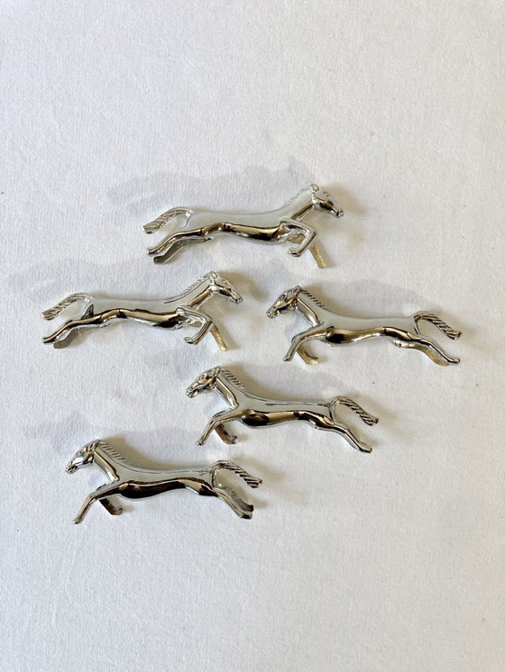 Image 1 of Cinco reposacuchillos de metal plateado con forma de caballo. Años 60.