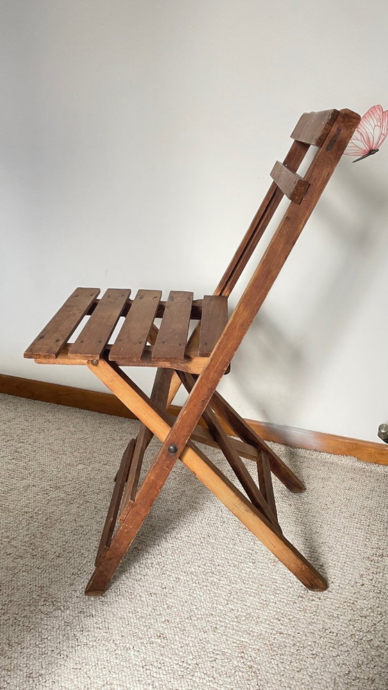 Image 1 of Antieke opklapbare houten stoel, een praktische en geometrische zitplaats. We zijn helemaal gecharmeerd van deze antieke stoel.