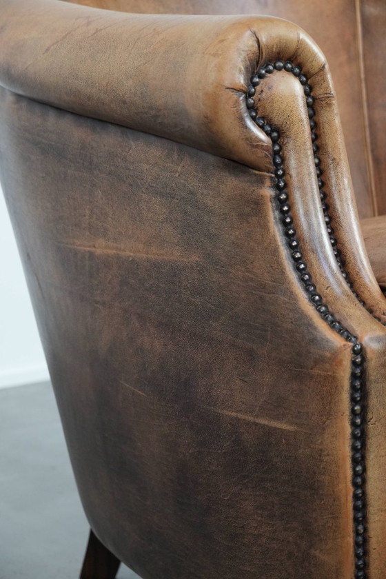 Image 1 of Clubfauteuil gemaakt van schapenleer afgewerkt met siernagels