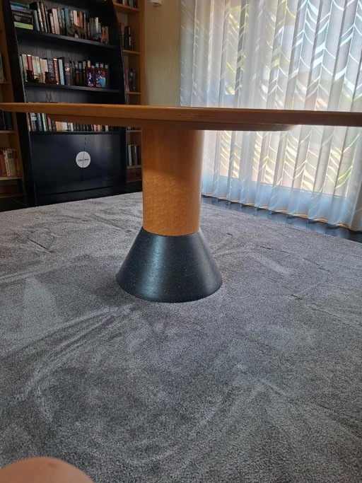 Mesa de comedor elíptica Arco Balance con seis sillas tipo cubo de cuero.