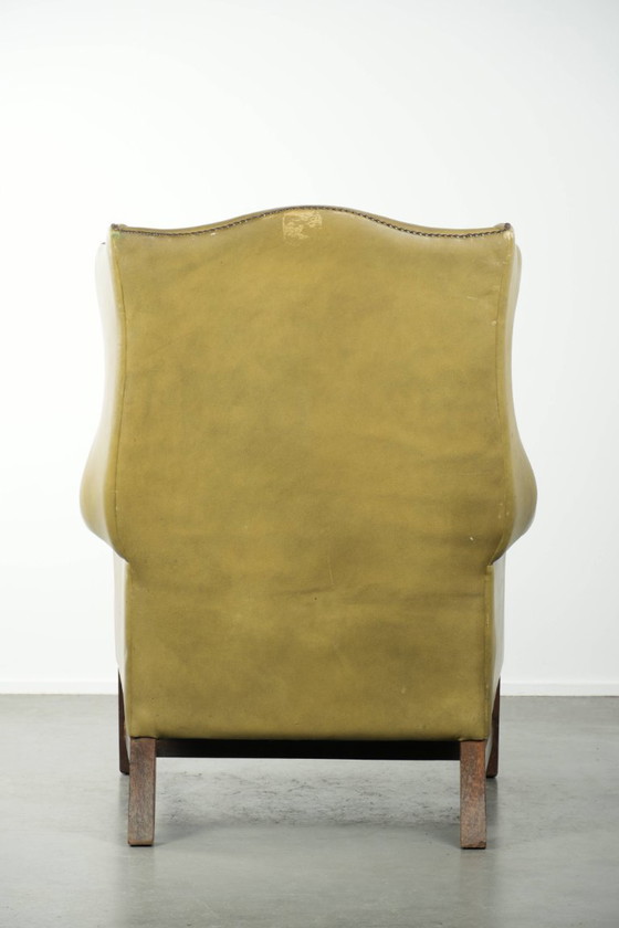 Image 1 of Fauteuil à oreilles ancien et élégant en cuir de vachette vert, de style classique de maison de campagne anglaise.