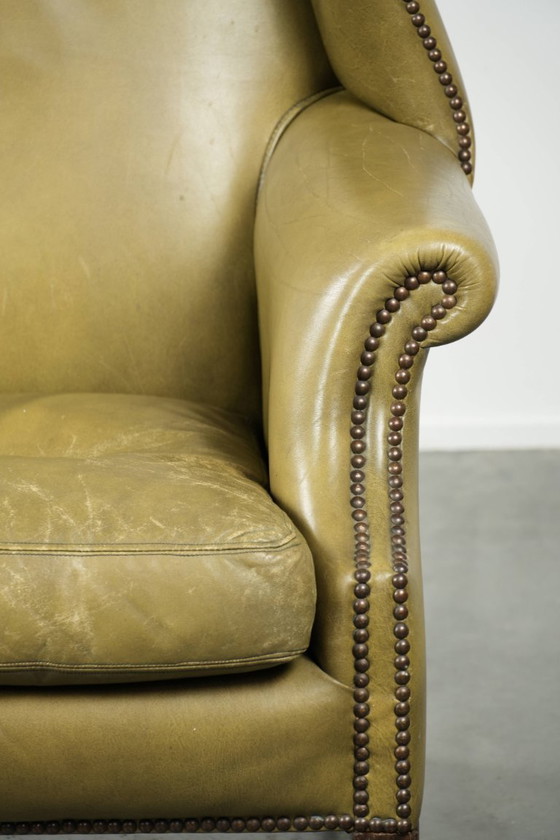 Image 1 of Fauteuil à oreilles ancien et élégant en cuir de vachette vert, de style classique de maison de campagne anglaise.