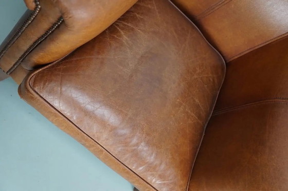 Image 1 of Dit paar cognackleurige leren clubfauteuils komt uit Nederland. Ze zijn bekleed met cognackleurig leer en zijn voorzien van meta