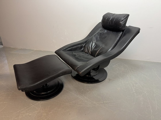 Image 1 of Skandinavisches Mid-Century-Design: Lounge-Sessel „Move“ aus schwarzem Leder mit passendem Hocker.