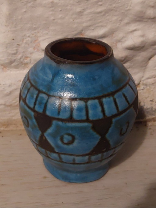 Blue Alain Maunier vase with 1950s ethnic designs on an orange background